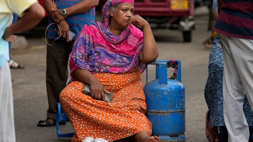 An elderly woman sits outside a police station in a protest demanding cooking gas in Colombo, Sri Lanka, Saturday, May 14, 2022. Sri Lanka’s economic crisis, the worst in its history, has completely recast the lives of the country’s once galloping middle class. For many families that never had to think twice about fuel or food, the effects have been instant and painful, derailing years of progress toward lifestyles aspired to across South Asia. (AP Photo/Eranga Jayawardena, file)